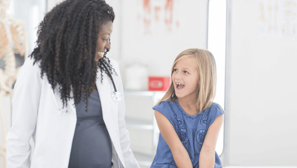 Doctor talking to a young girl in an exam room
