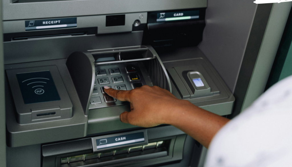 This is an image of a person pushing keys on an ATM.