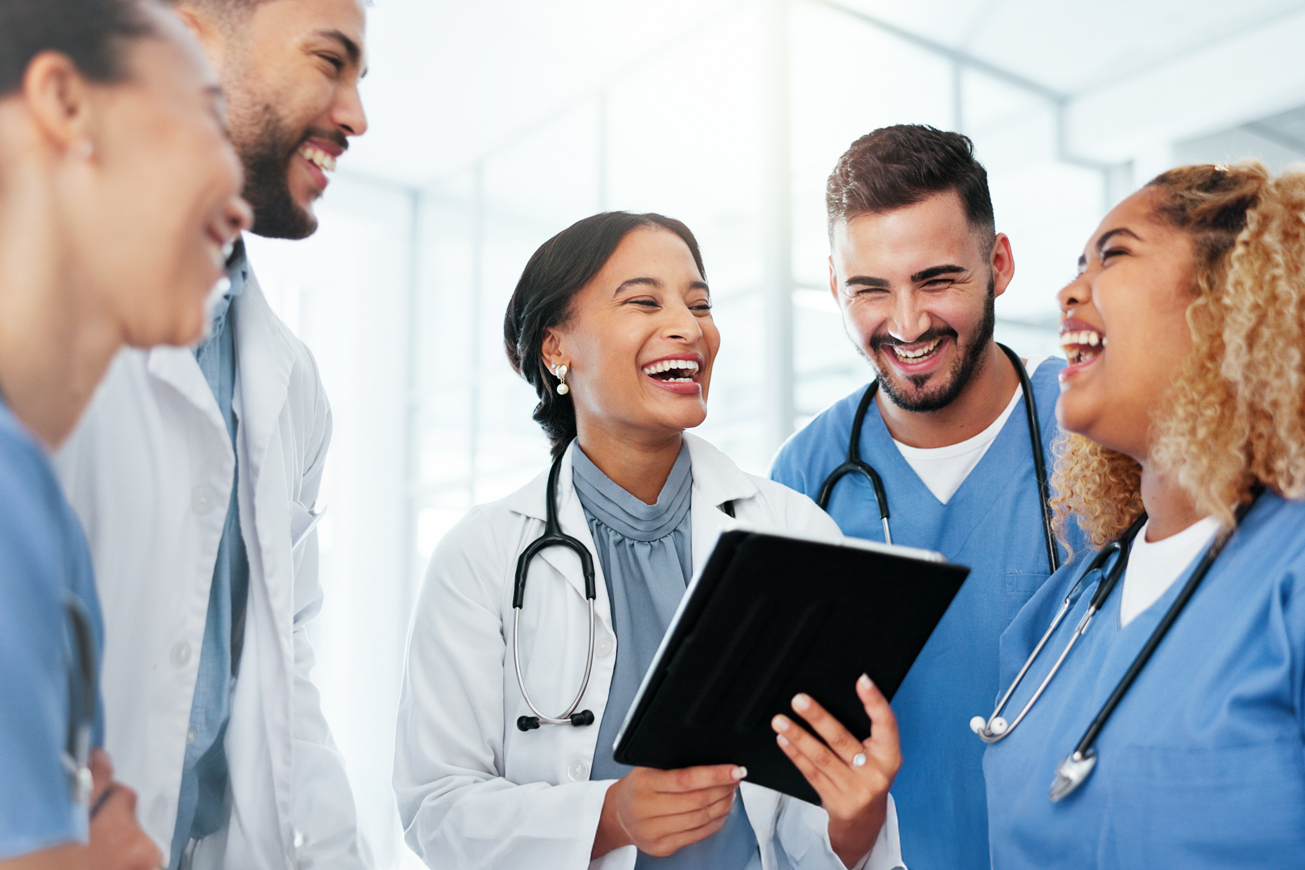 Doctors talking and laughing in a hallway.