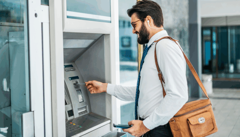 A man in professional clothing using an ATM