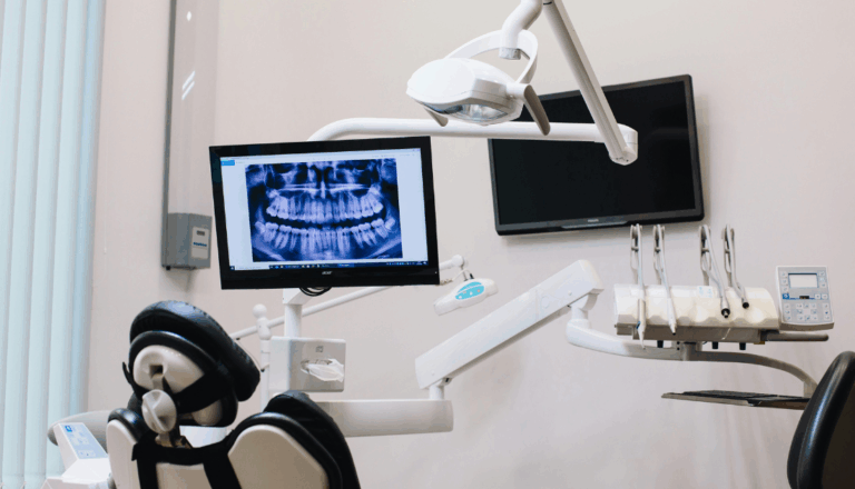 A dentist’s office with a dental x-ray displayed on the screen.