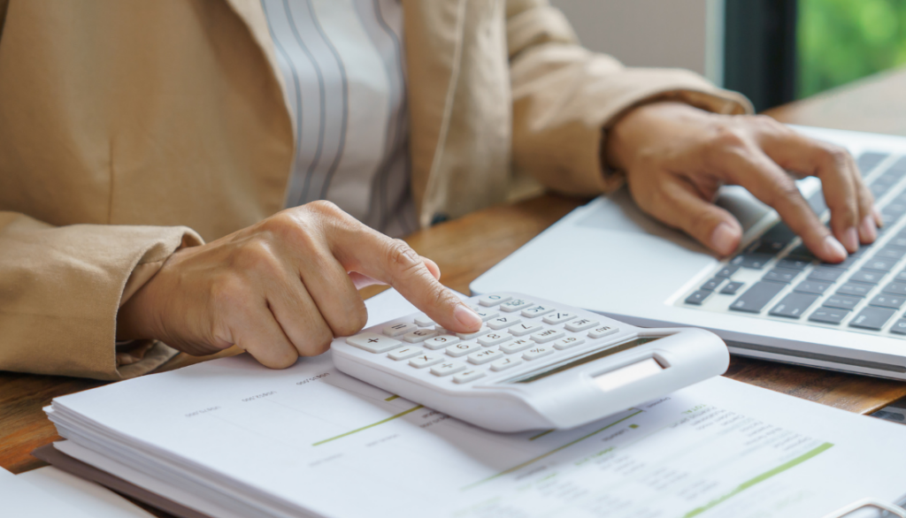 A person typing on a calculator