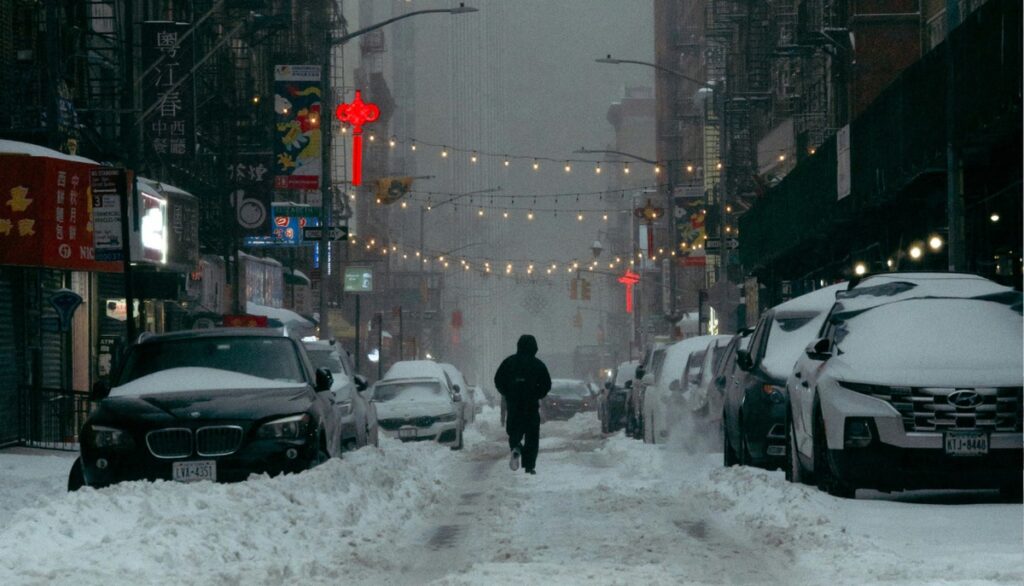 A person walking through a snowy city.
