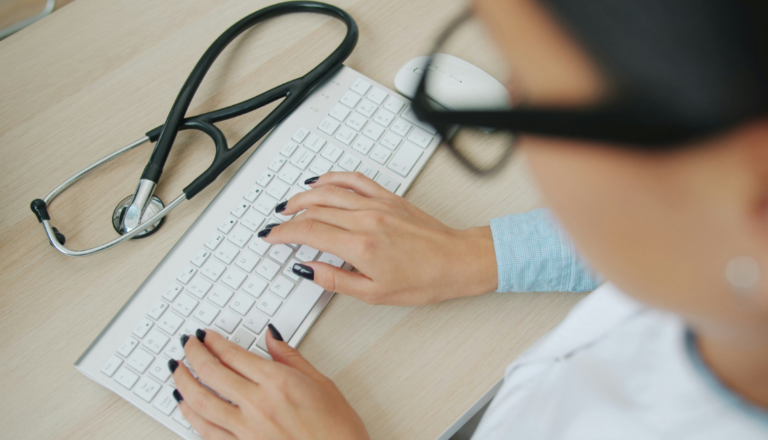 A doctor typing on a keyboard