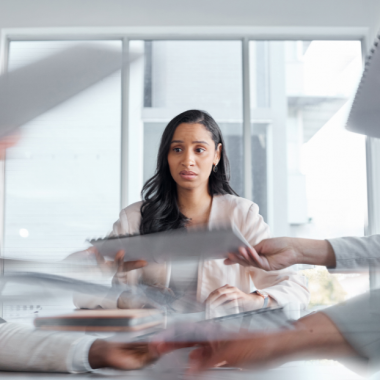 This is a picture of a woman and many papers passing back and forth.