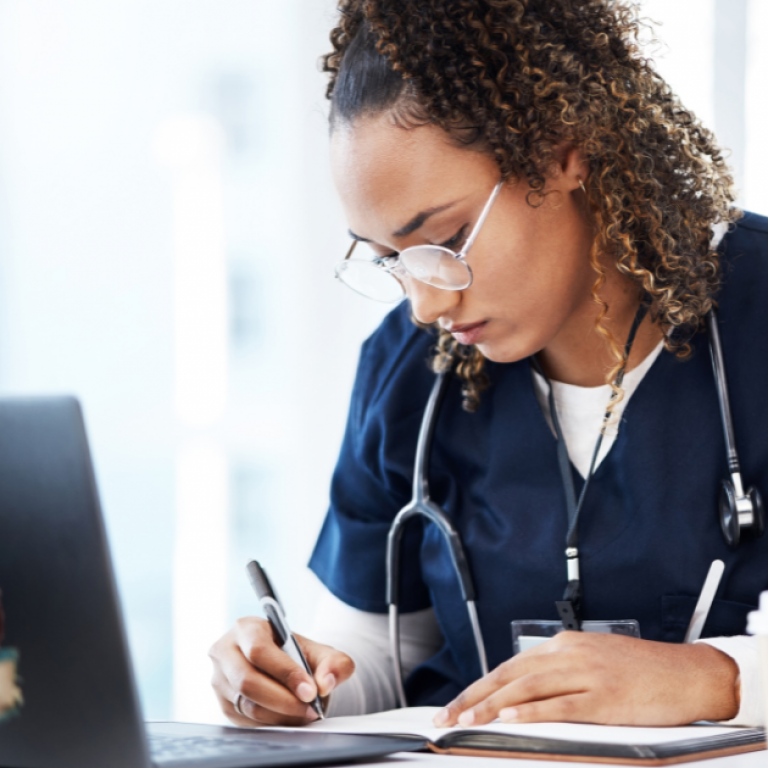 A young doctor or medical student writing in a notebook