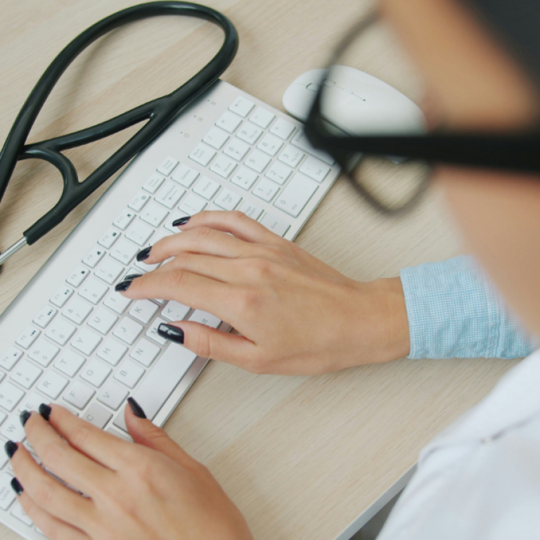 A doctor typing on a keyboard
