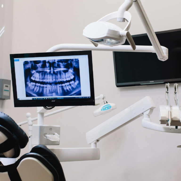 A dentist’s office with a dental x-ray displayed on the screen.